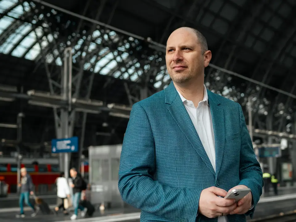 Marc Will, Geschäftsführer von Intertours, steht mit Smartphone in der Hand im Frankfurter Hauptbahnhof.